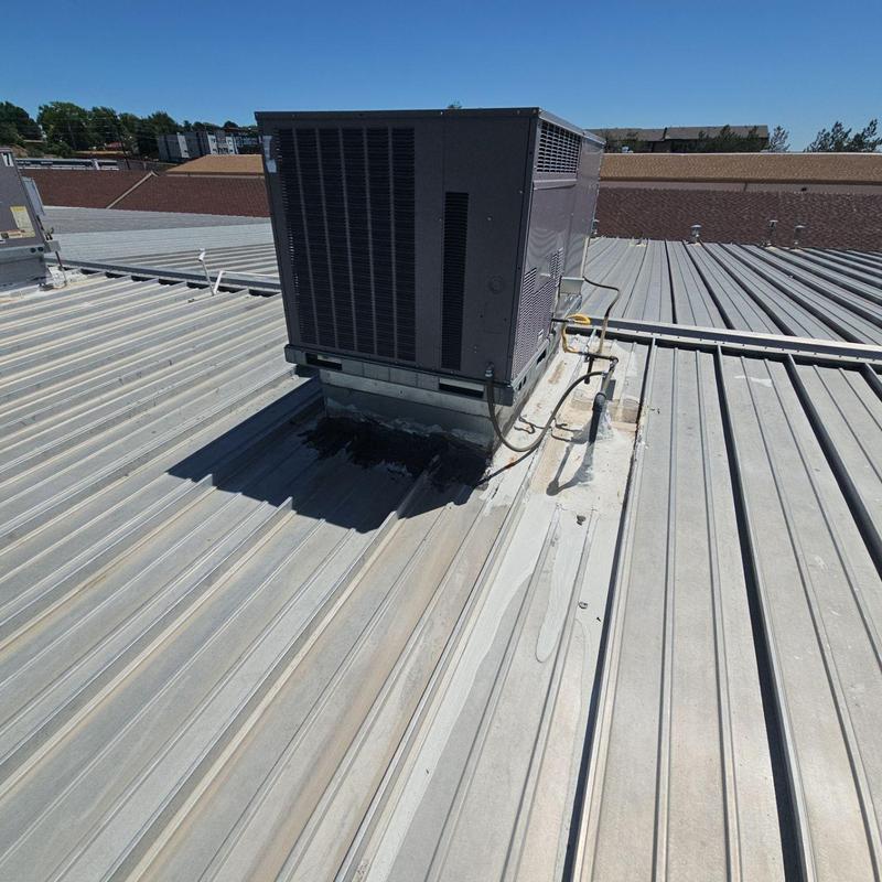 Metal rooftop HVAC unit on corrugated roof panels Metal rooftop HVAC unit on corrugated roof panels