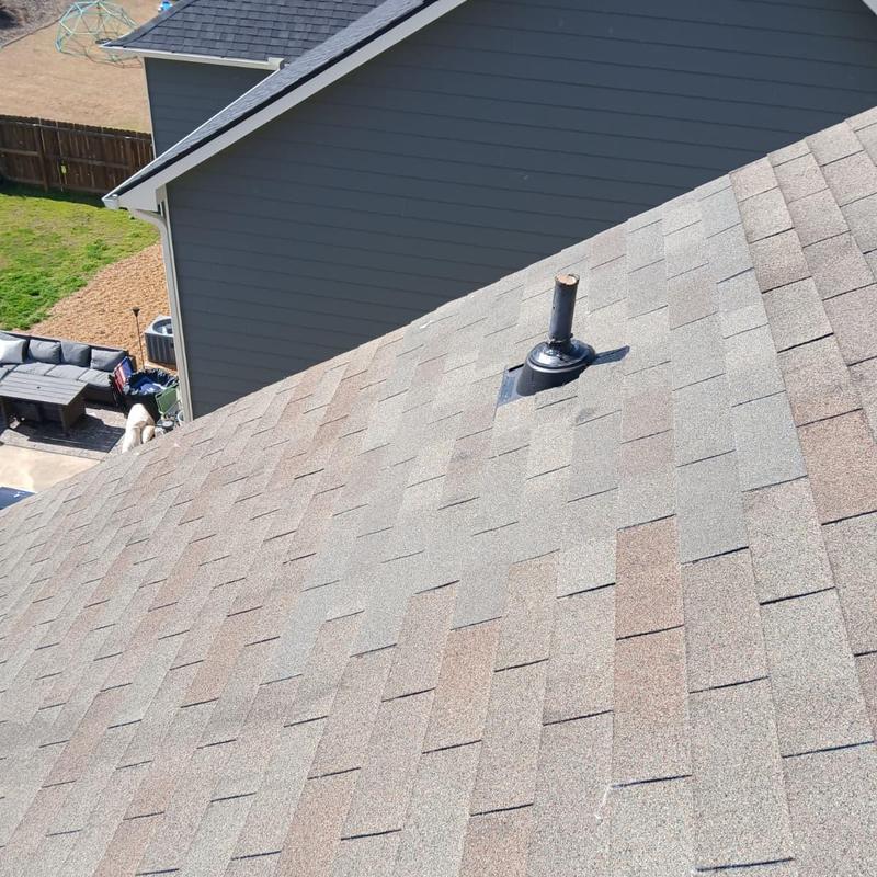Pipe boot and surrounding roofing shingles on sloped roof