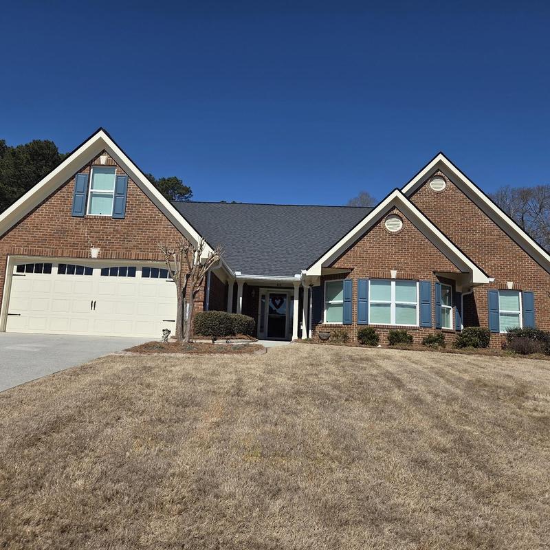 Shingle roof inspection on suburban brick house