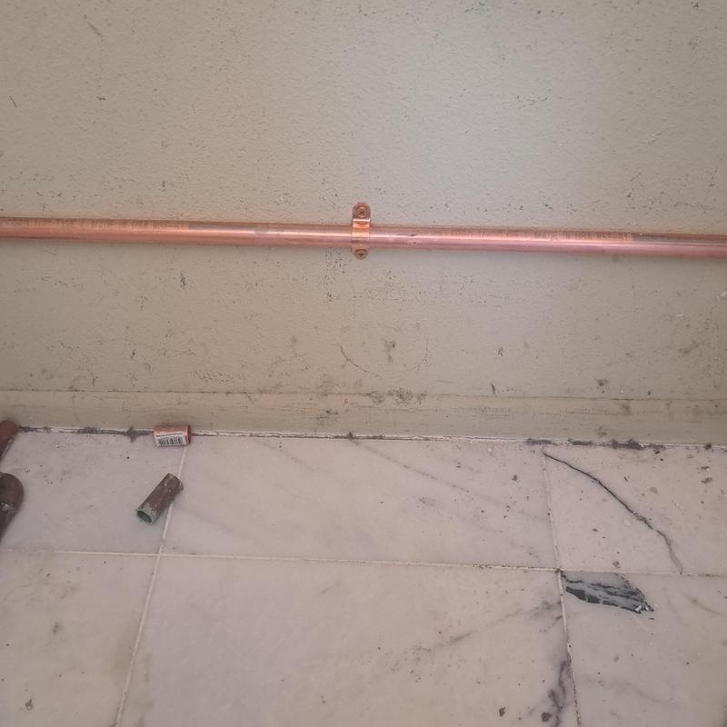 Copper water line rerouted above ground wall mounting