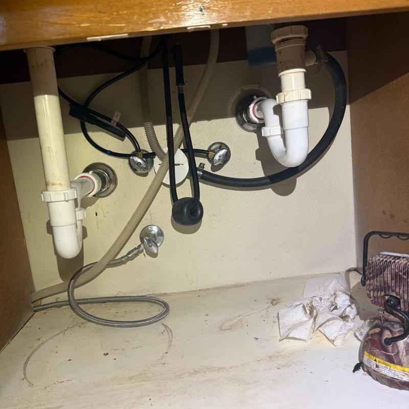 Sink drain pipes and water supply lines under cabinet