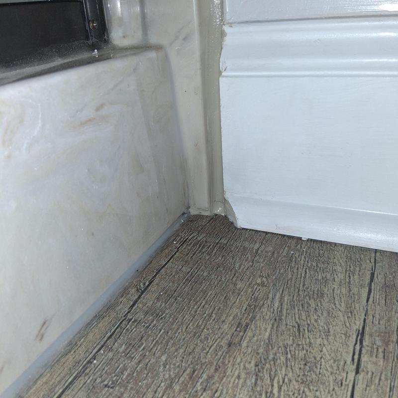 Bathtub corner silicone sealing with painted baseboard trim