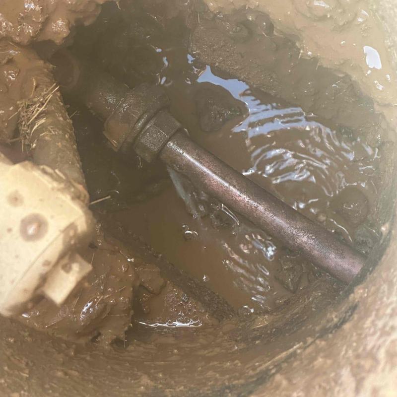 Leaking underground pipe joint in muddy excavation site Leaking underground pipe joint in muddy excavation site
