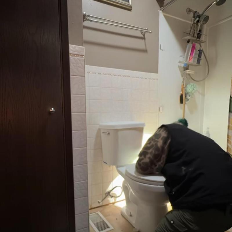 Toilet installation in residential bathroom with technician