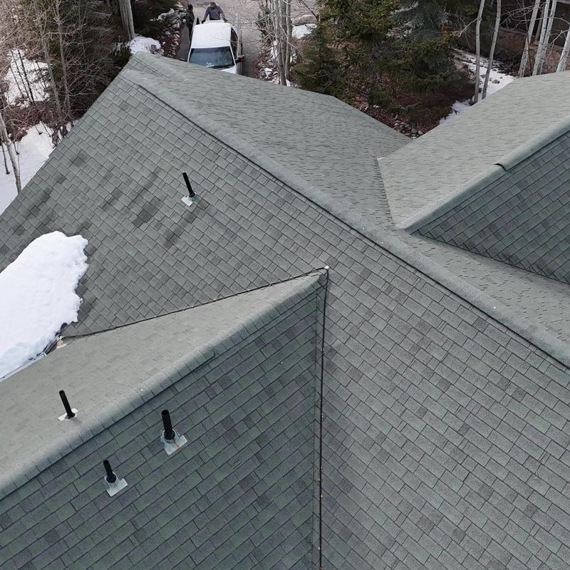 Asphalt shingle roof with vent pipes and snow patches Asphalt shingle roof with vent pipes and snow patches