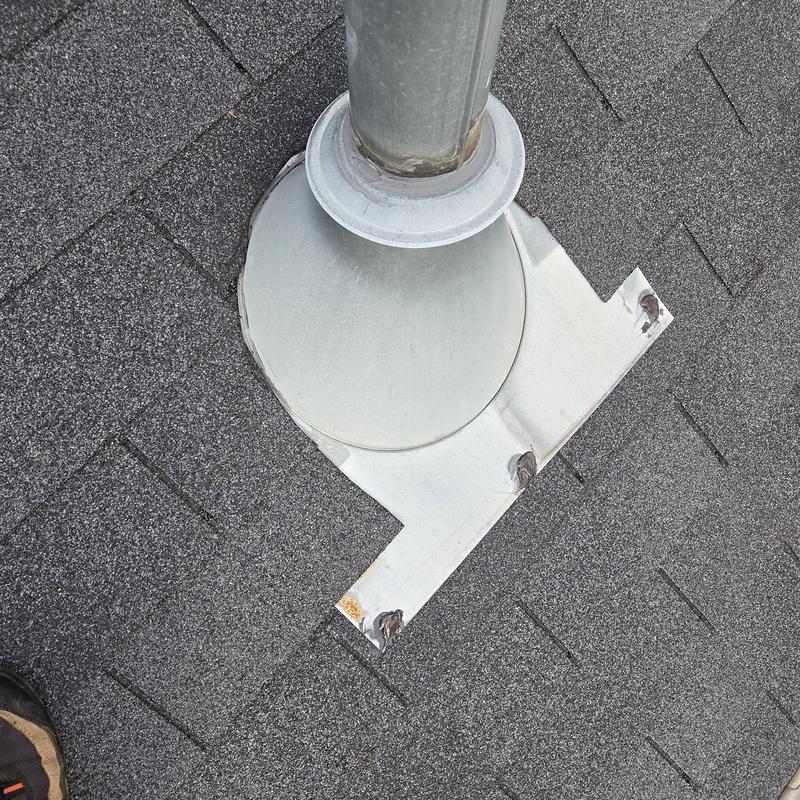 Roof pipe flashing with sealant on asphalt shingles