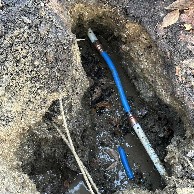 Blue PEX piping in muddy trench excavation site Blue PEX piping in muddy trench excavation site