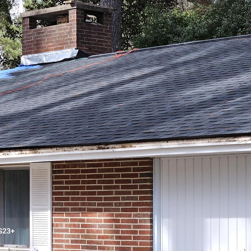 Asphalt shingle roof with brick chimney and siding repairs