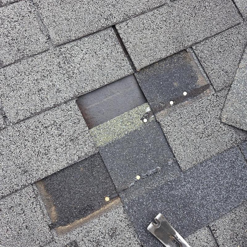 Asphalt shingles with missing pieces and exposed nails