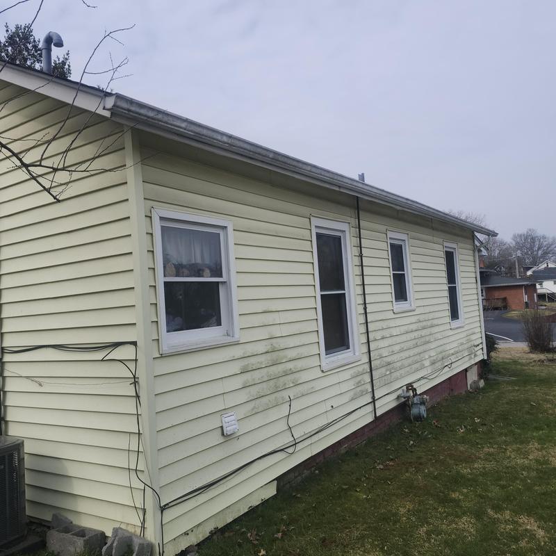 House siding with moss and dirt buildup on exterior wall
