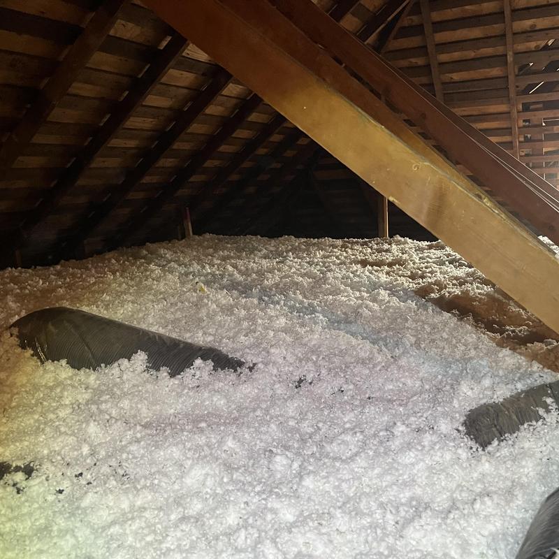 Attic insulation with ductwork in wooden attic space