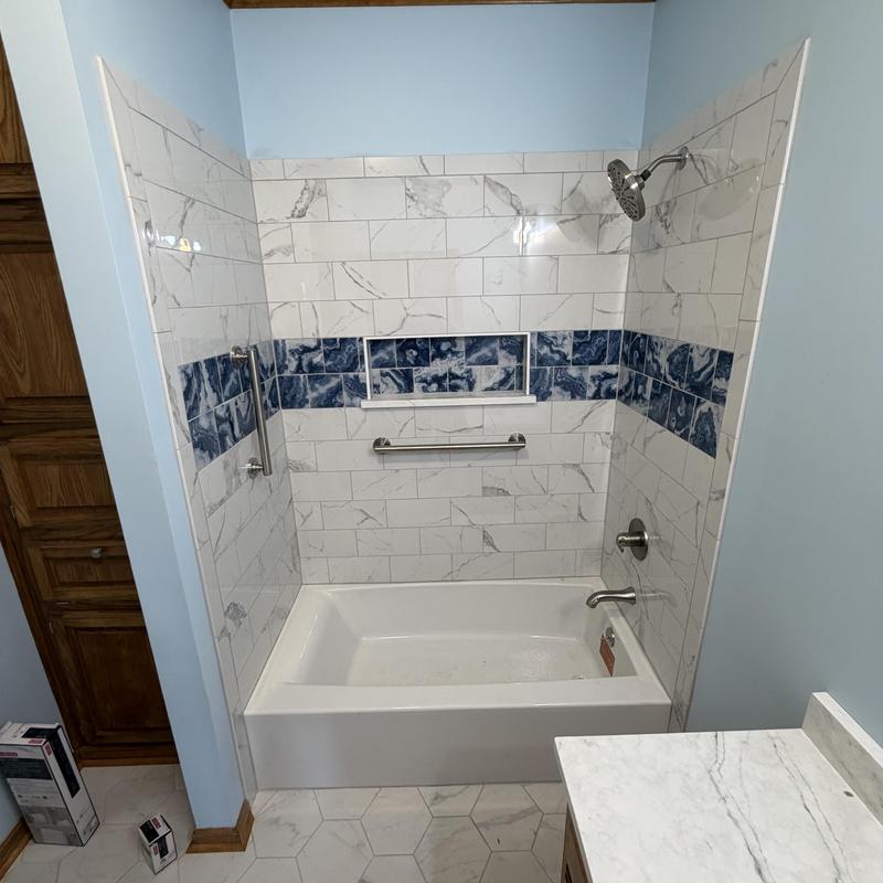 Custom bathtub and tiled shower with blue accent tiles