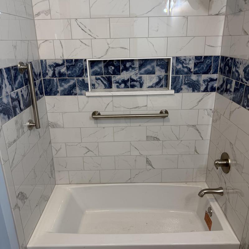 Custom bathtub with blue tile and grab bars