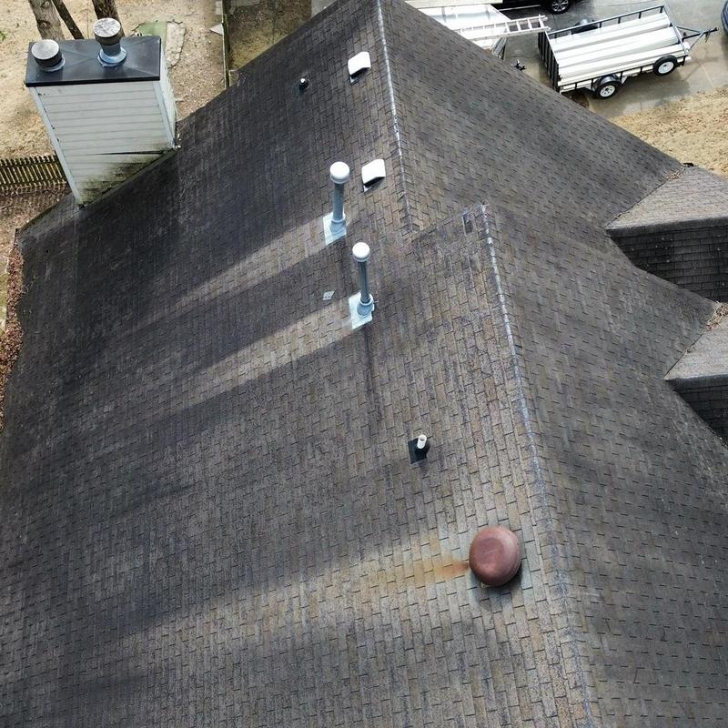 Asphalt shingle roof with vent pipes and chimney viewed from above