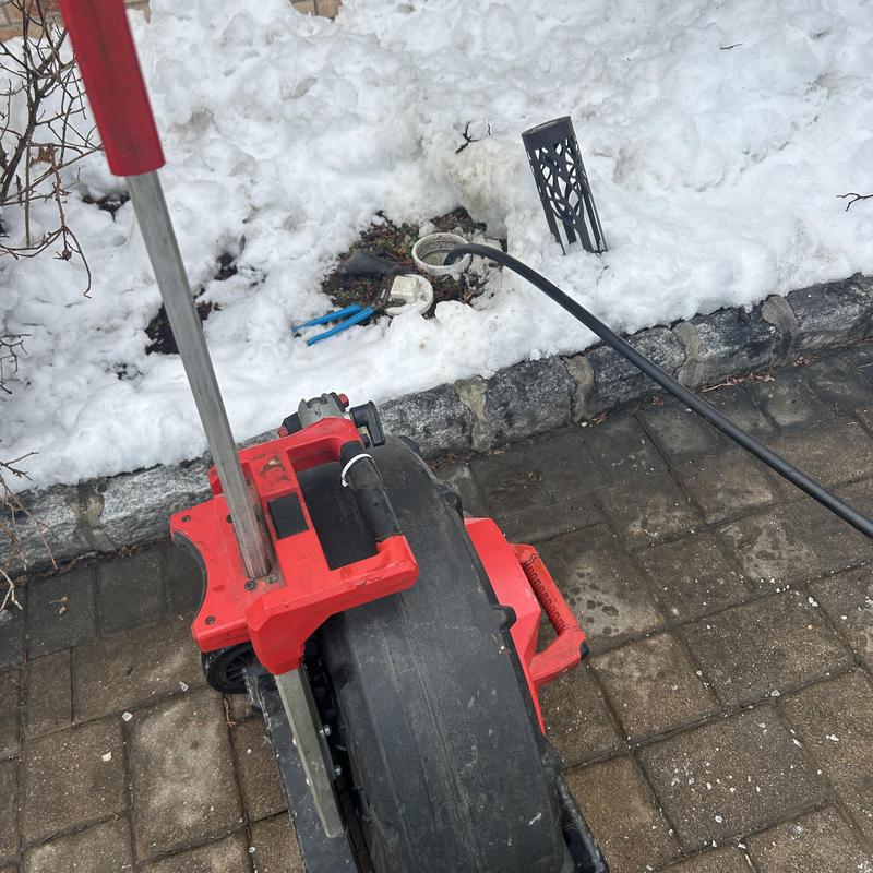 Drain cleaning jet machine near outdoor drain in snow
