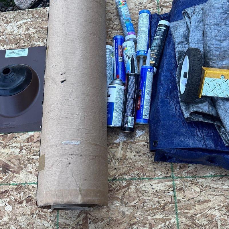 Roof underlayment roll and roof sealant tubes on plywood Roof underlayment roll and roof sealant tubes on plywood