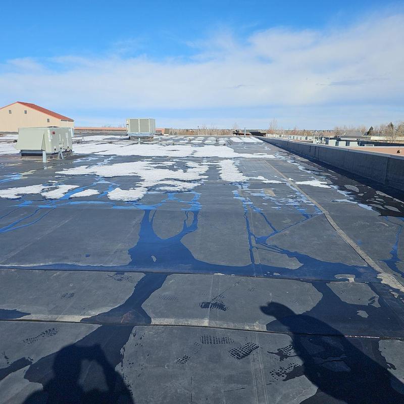 Flat roof membrane with water pooling and damage Flat roof membrane with water pooling and damage