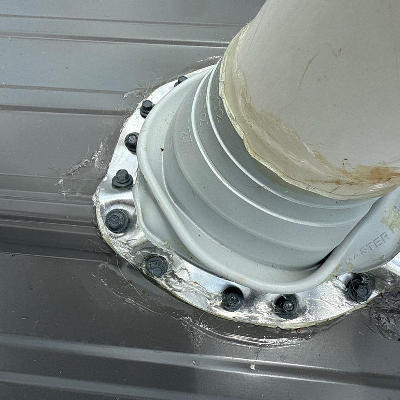 Roof pipe flashing with sealant on metal roof