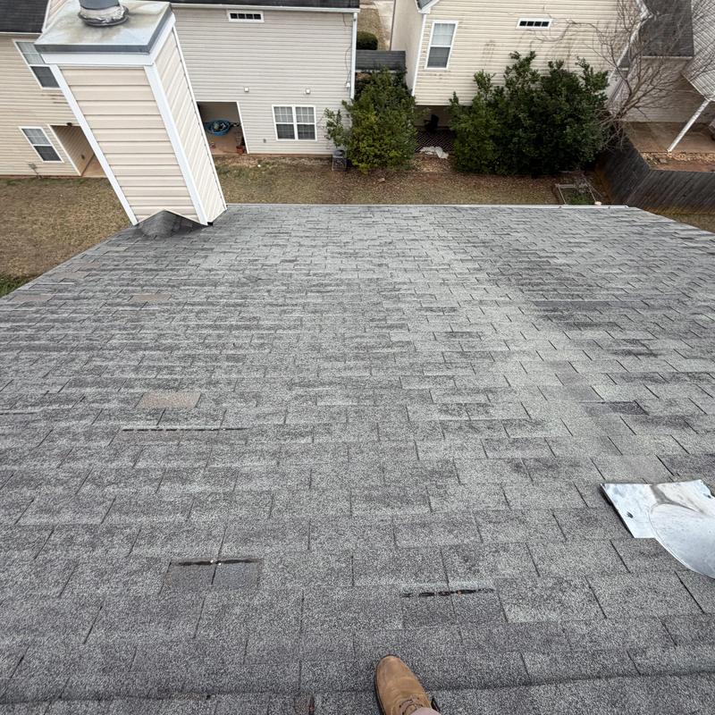 Faded slate shingle roof with missing shingles and tarp