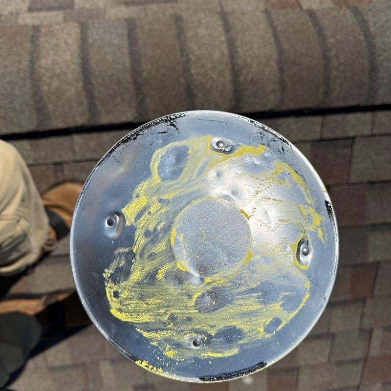 Metal roof vent cap with hail impact dents