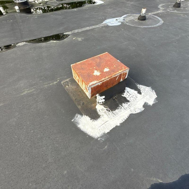 Roof vent rust and sealant on flat commercial roof
