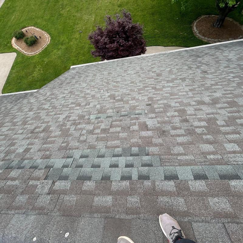 Roof shingles with visible hail damage impact