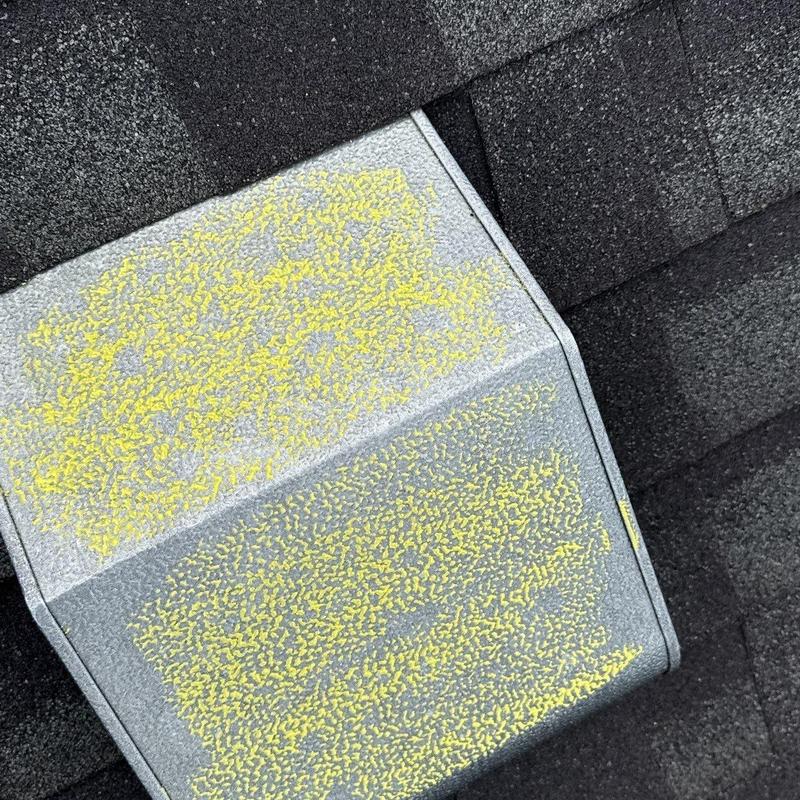 Roof metal vent with marked hail damage on shingles