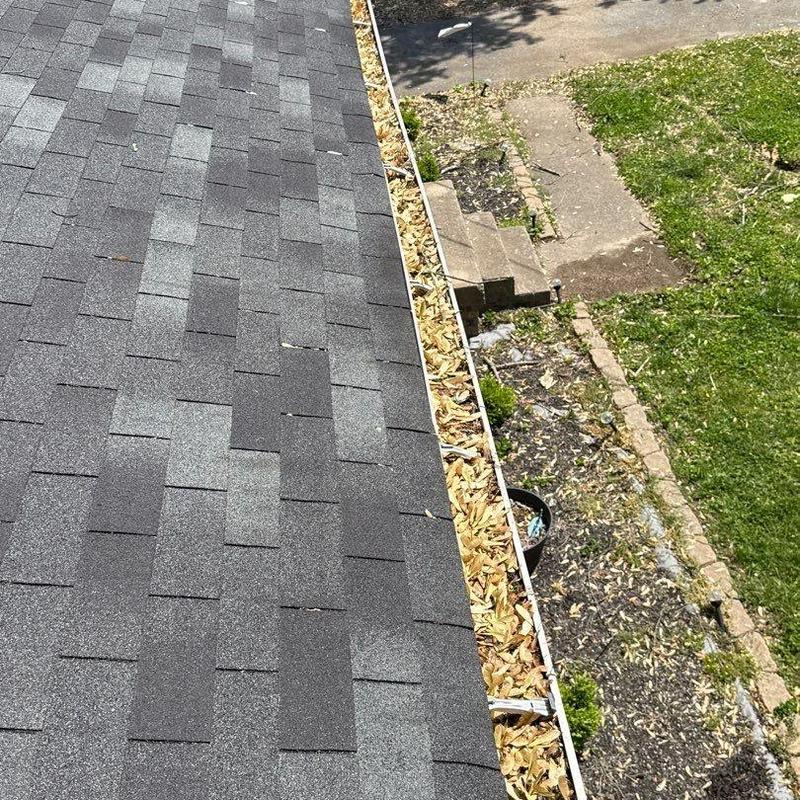 Asphalt shingles with hail damage near gutter