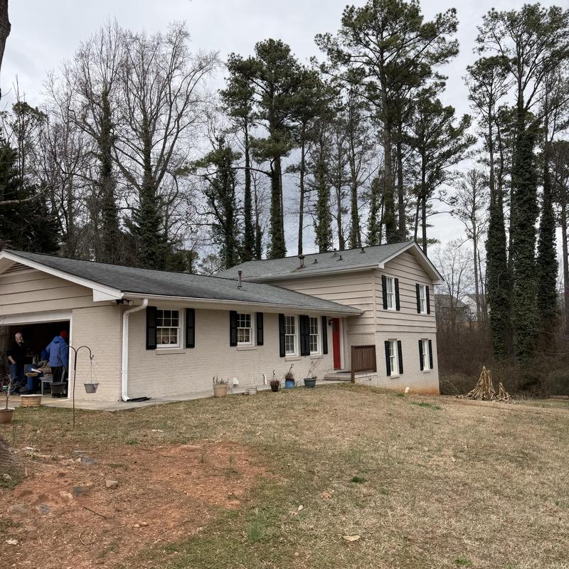 Downspout with loose straps on two-story house exterior
