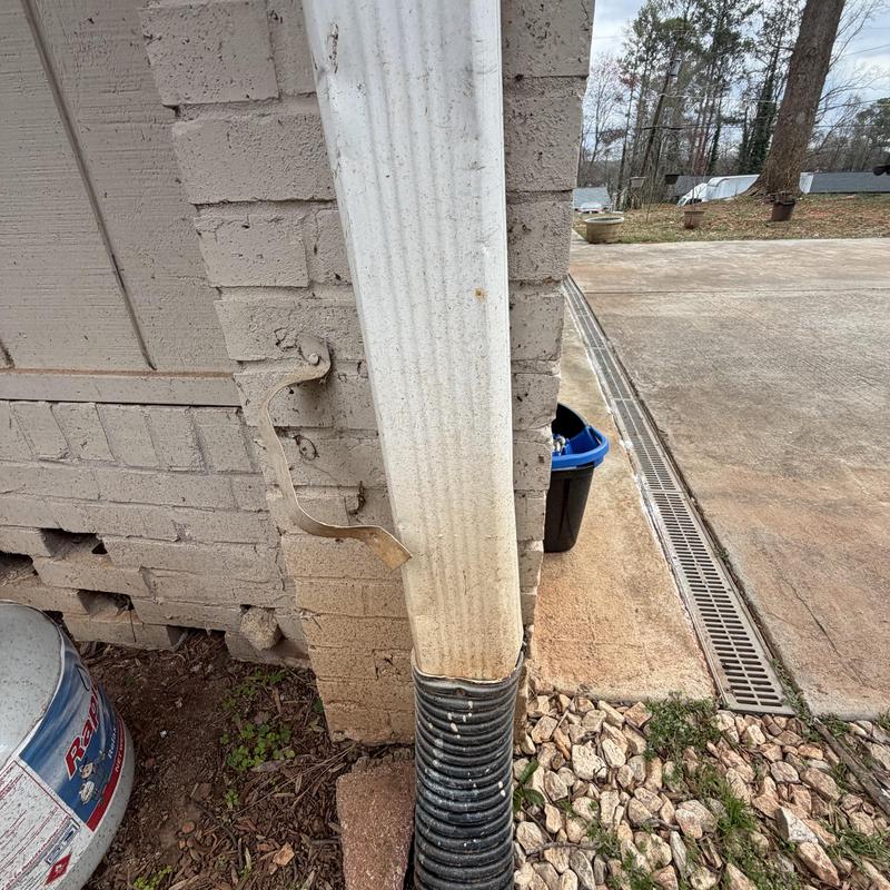 Downspout strap detached from brick wall
