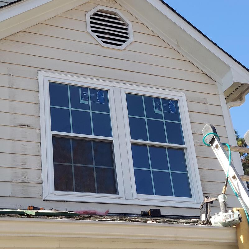 Double-hung windows with grid pattern on vinyl siding