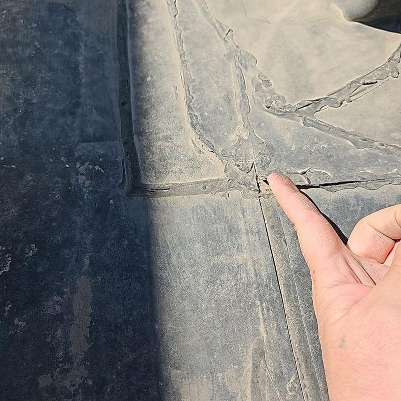 EPDM roof seam with visible cracks and damage EPDM roof seam with visible cracks and damage