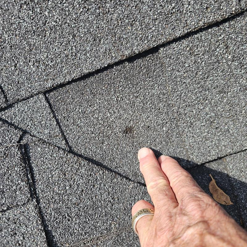 Asphalt shingles with hail damage spot close-up