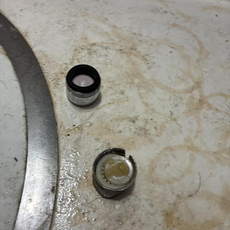 Basin faucet aerator parts on dirty surface