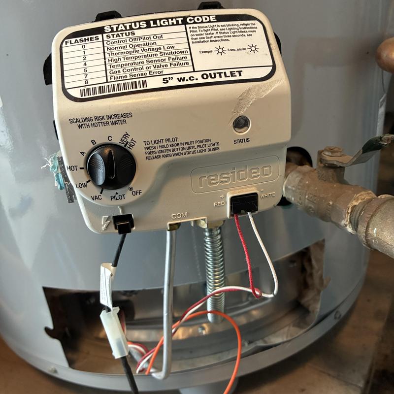 Gas control valve on water heater with wiring and pipes