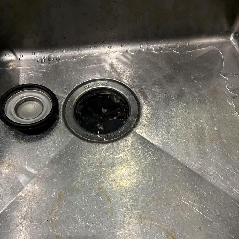 Garbage disposal reset in stainless steel sink drain