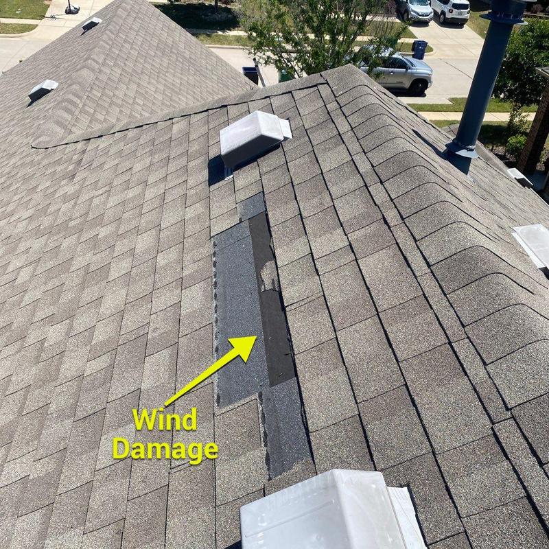 Roof shingles with wind damage on residential roof
