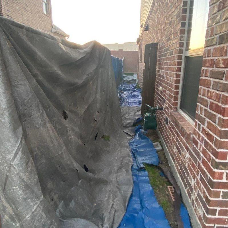 Landscape protection tarps beside brick house Landscape protection tarps beside brick house