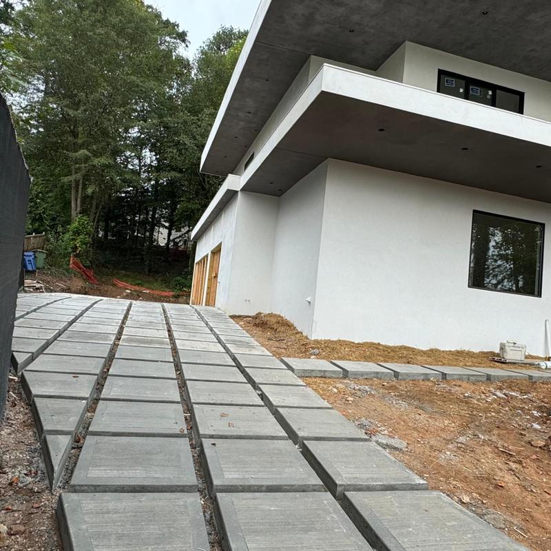 Concrete driveway installation at modern home site
