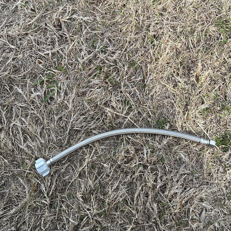 Toilet supply line on dry grass surface