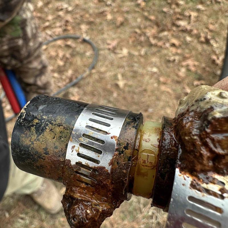 Rusty underground pipe joint with metal clamps Rusty underground pipe joint with metal clamps