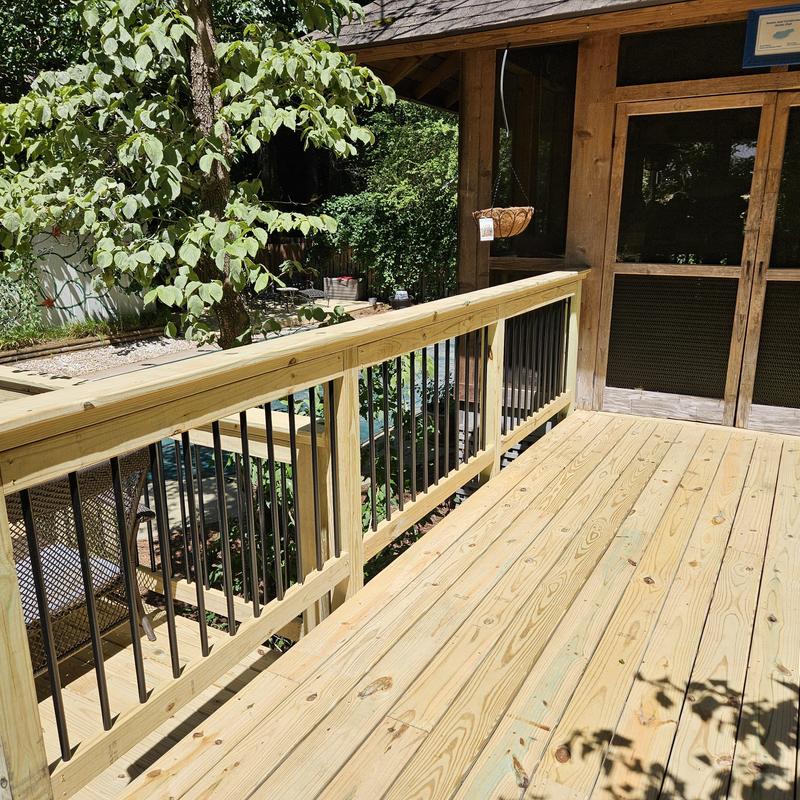 Wooden deck with metal railing near poolhouse patio Wooden deck with metal railing near poolhouse patio
