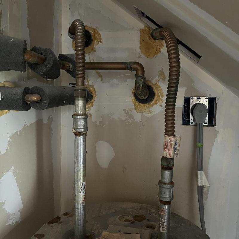 Electric water heater gas and water connections under stairs