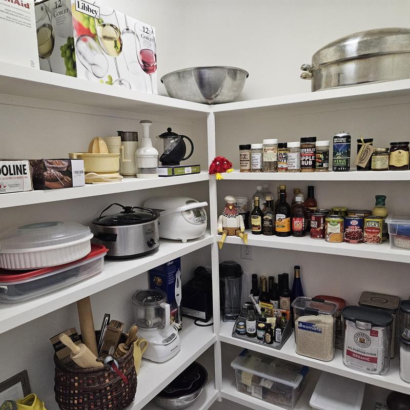 Pantry shelving with organized kitchen appliances and spices Pantry shelving with organized kitchen appliances and spices