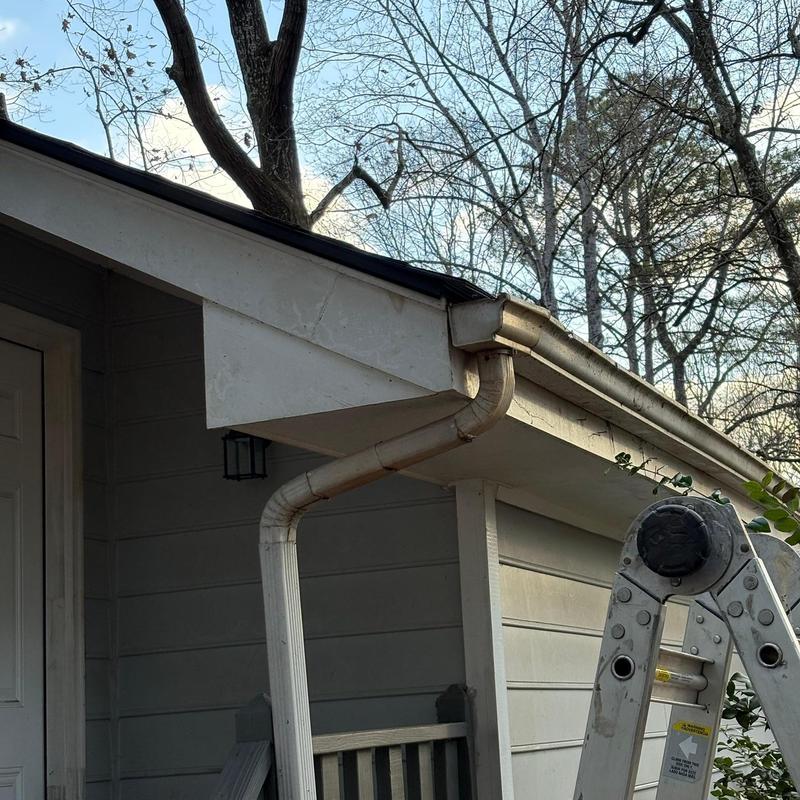 Downspout reattached to gutter system on house exterior