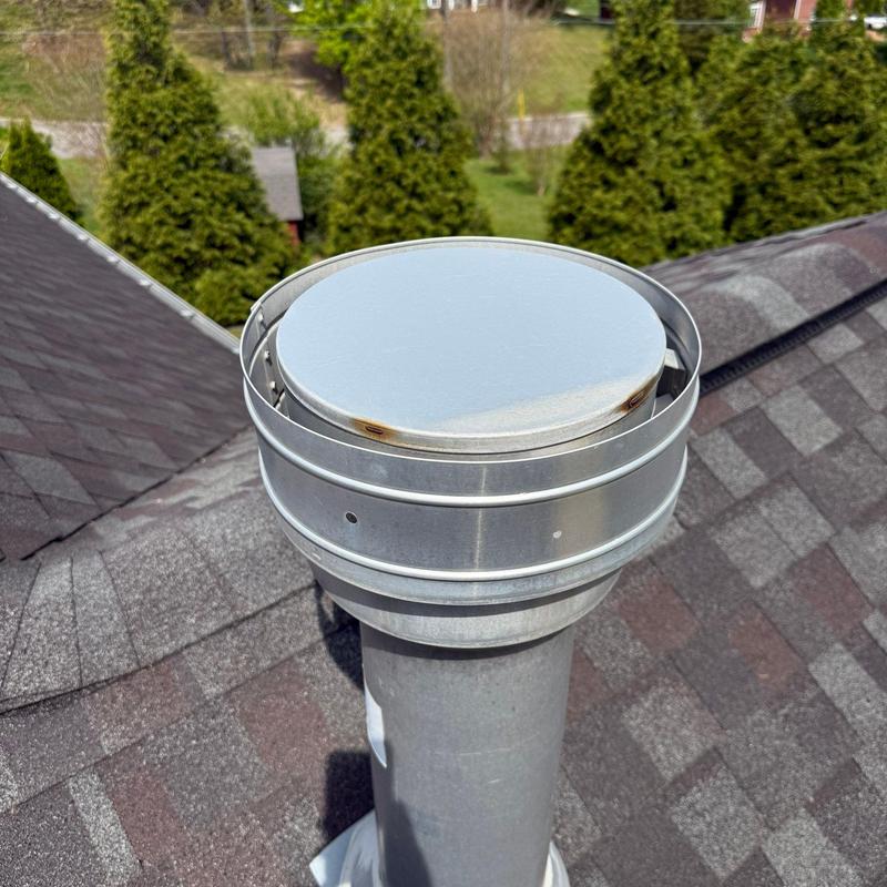 Roof vent pipe with metal cap on asphalt shingles