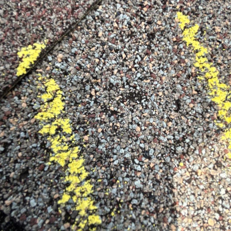 Roof shingle with hail damage marked for inspection