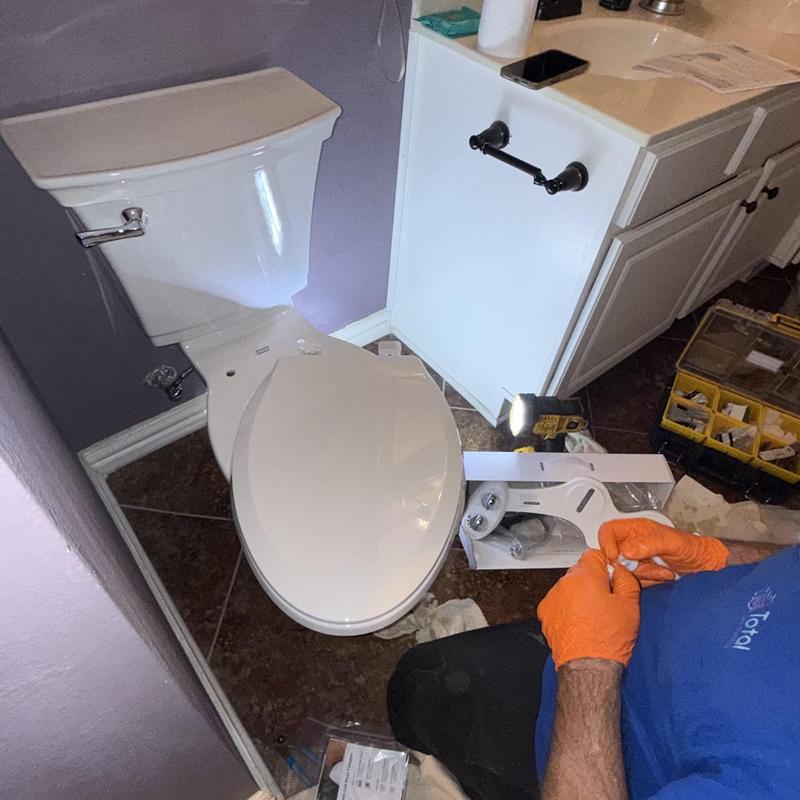 Toilet installation in bathroom with plumbing tools