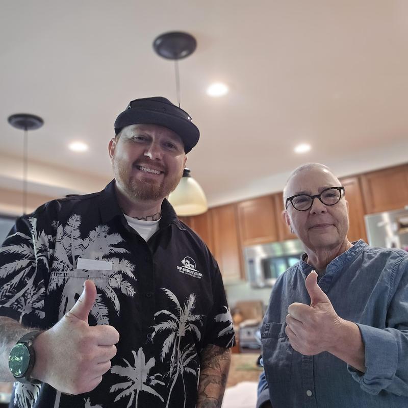 Drain system service with thumbs up from technician and customer