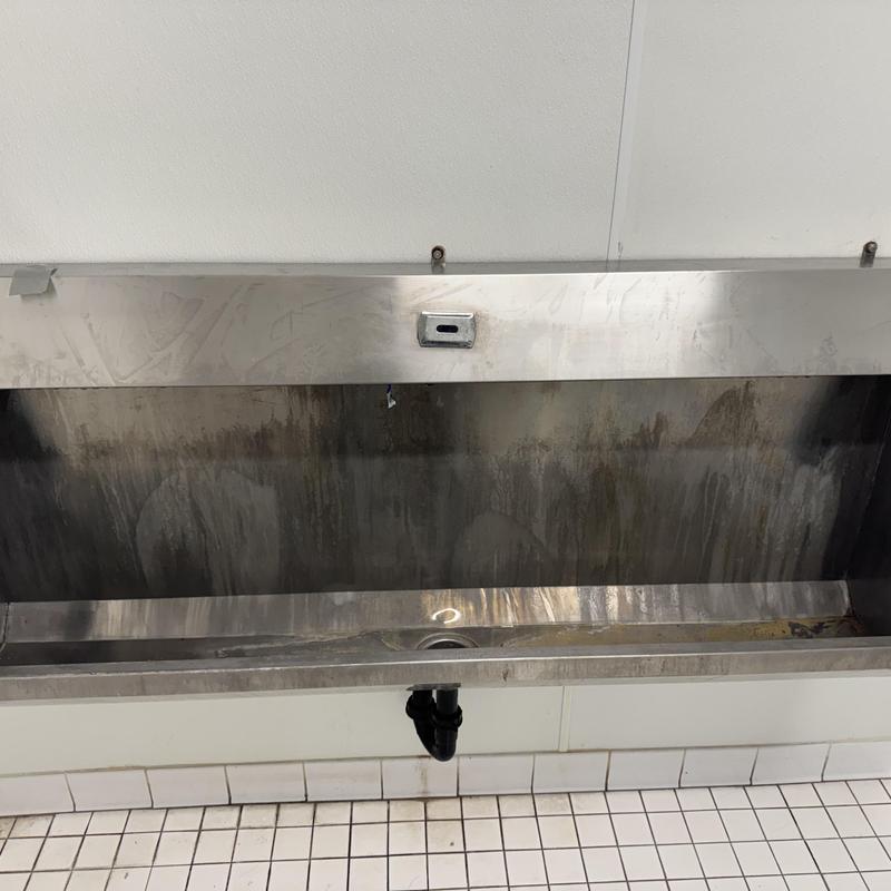 Commercial urinal with over pressurized water spray system